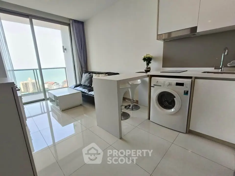 Modern apartment with ocean view, sleek kitchen, and cozy living area.