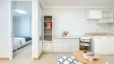 Modern open-plan living room with stylish decor and cozy bedroom view, perfect for urban living.