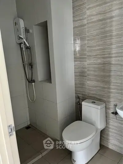 Modern bathroom with sleek shower and toilet in contemporary design.