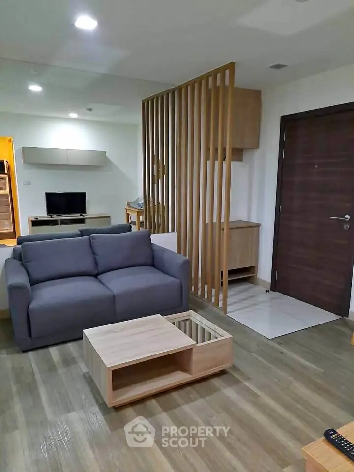 Modern living room with stylish wooden partition and cozy furniture in open layout apartment.