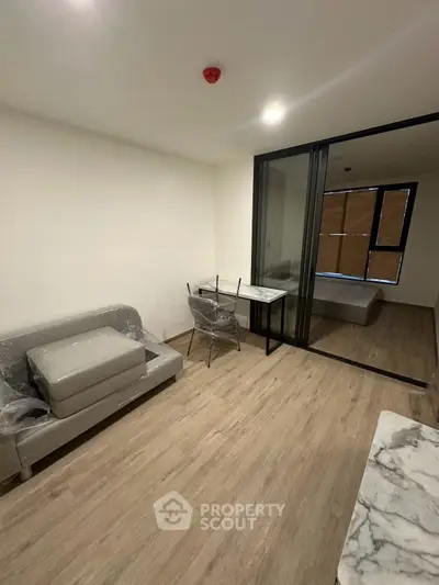 Modern apartment interior with sliding glass partition and minimalist furniture