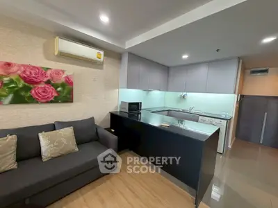 Modern open-layout kitchen and living room with sleek design and cozy ambiance.