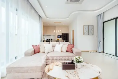Luxurious modern living room with elegant decor and open kitchen layout, featuring a cozy sectional sofa and stylish accents.