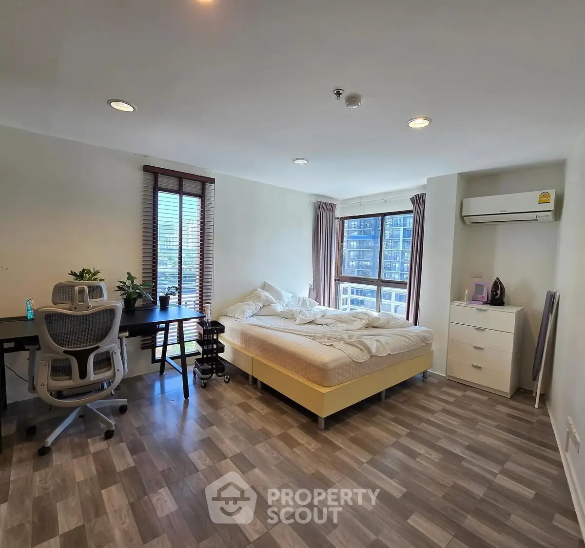 Spacious bedroom with modern decor and city view, ideal for urban living.