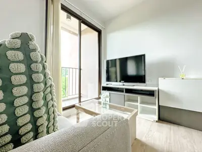 Modern living room with cozy sofa and large TV, featuring a balcony view.