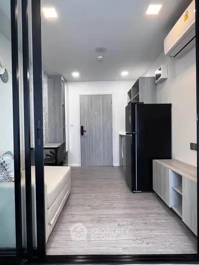Modern apartment interior with sleek design and open layout, featuring a cozy living area and compact kitchen.