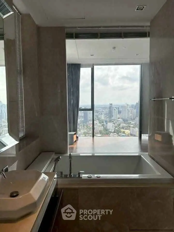 Luxurious bathroom with stunning city view from high-rise apartment.