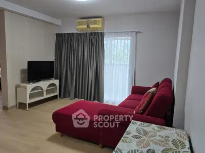 Cozy living room with red sofa and natural light from window