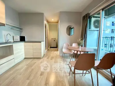 Modern open-plan kitchen and dining area with natural light and sleek furnishings.