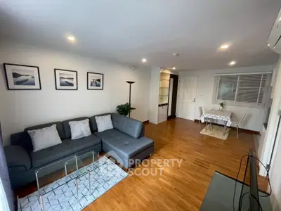 Spacious living room with modern decor and hardwood floors in a stylish apartment.