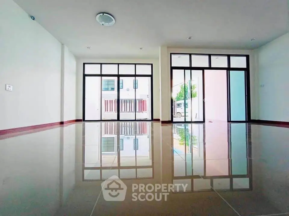 Spacious empty room with large windows and glossy tiled floor, perfect for customization.