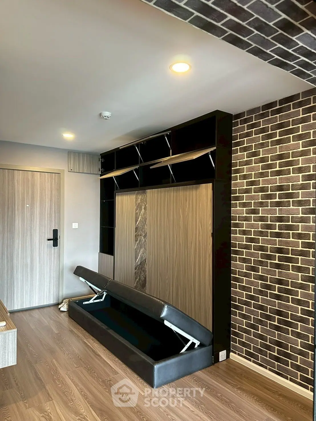 Modern living room with stylish brick accent wall and hidden storage bench