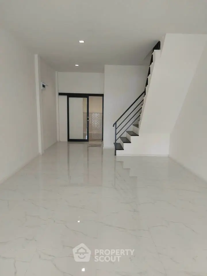 Spacious modern living room with sleek staircase and glossy marble flooring