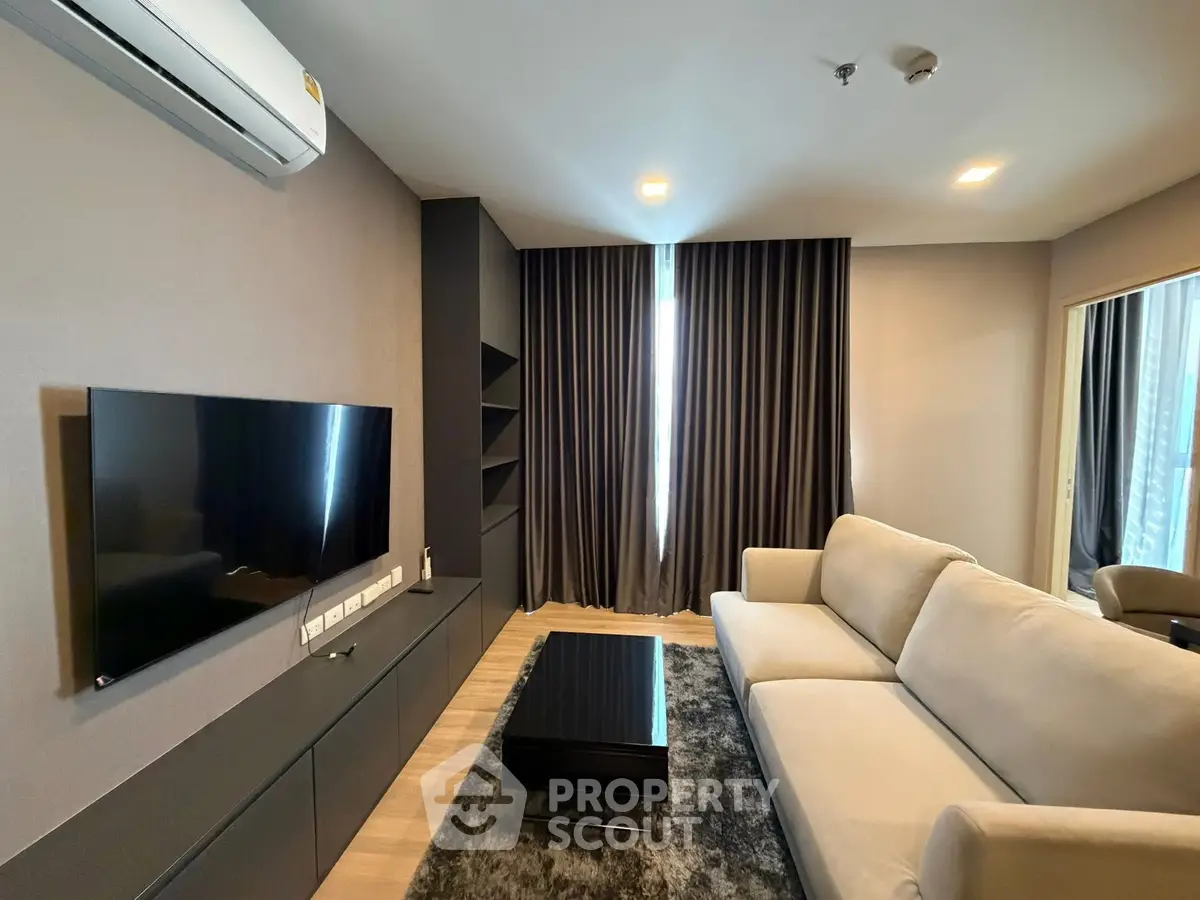 Modern living room with sleek furniture and large TV, perfect for relaxation.