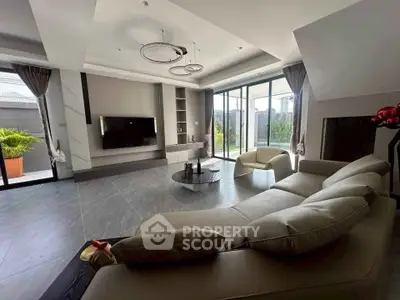 Luxurious modern living room with sleek furniture and large windows offering a stunning garden view.