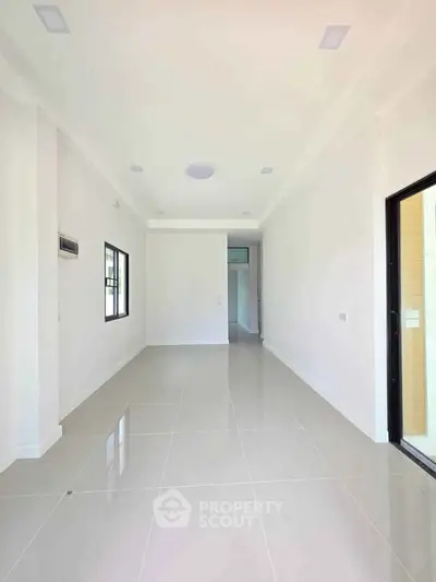 Spacious and bright interior with sleek tile flooring and large windows, perfect for modern living.