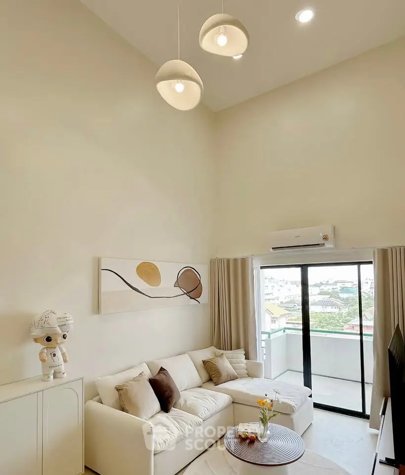 Modern living room with high ceiling and balcony view, featuring elegant decor and natural light.