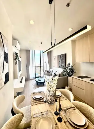 Modern open-plan living room with dining area and balcony view in stylish apartment.