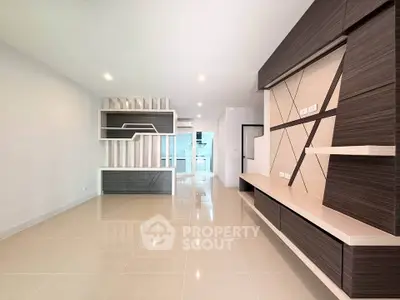 Spacious modern living room with sleek built-in shelving and glossy tiled floors.