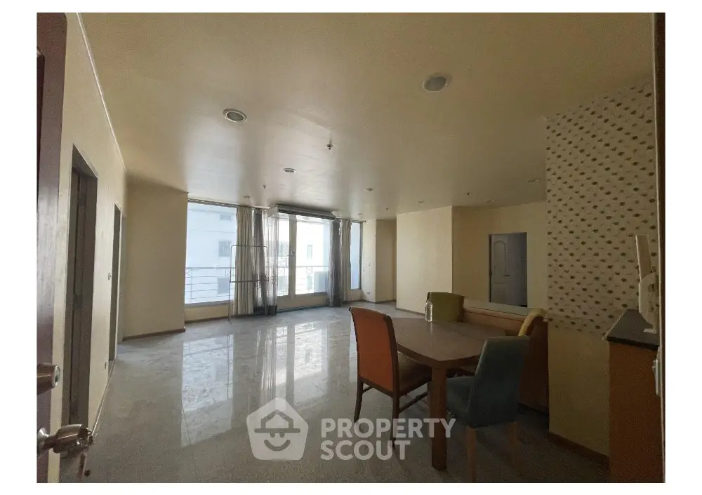Spacious living room with modern dining area and large windows for natural light
