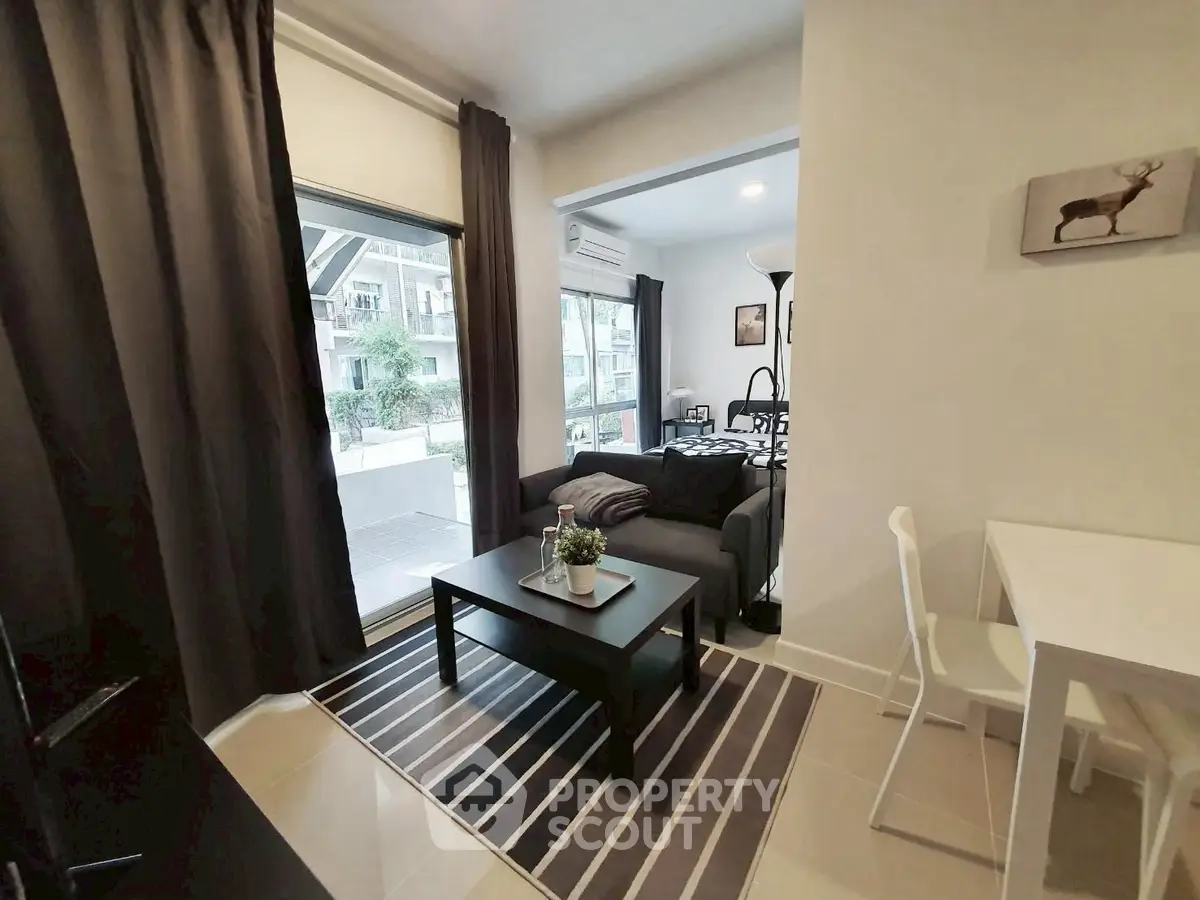 Modern living room with stylish decor and large windows in a cozy apartment.