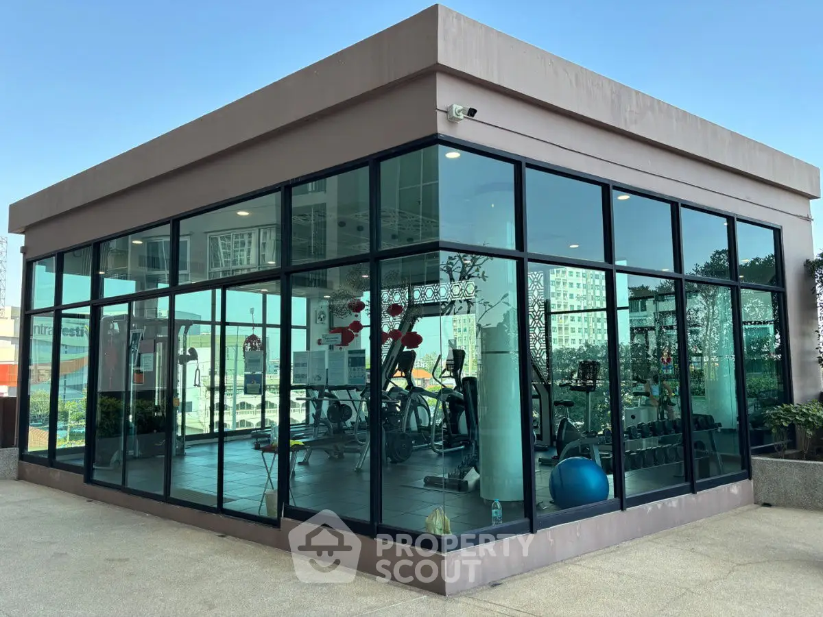 Modern glass-walled gym with exercise equipment in a real estate property