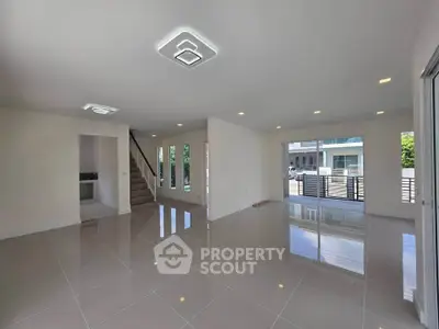 Spacious modern living room with glossy tiled floors and stylish lighting in a contemporary home.