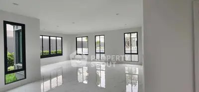 Spacious modern living room with large windows and glossy floors