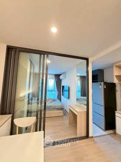 Modern apartment interior with sliding glass doors and cozy bedroom view.