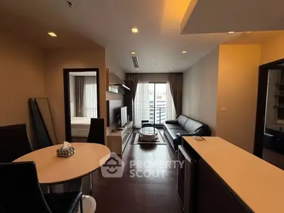 Modern open-plan living room with sleek furniture and balcony access.