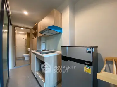 Modern compact kitchen with sleek appliances and wooden cabinetry