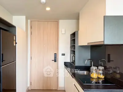 Modern kitchen with sleek cabinetry and black countertops in a stylish apartment.