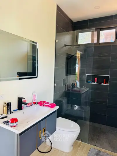 Modern bathroom with sleek design, glass shower, and stylish vanity in a contemporary home.