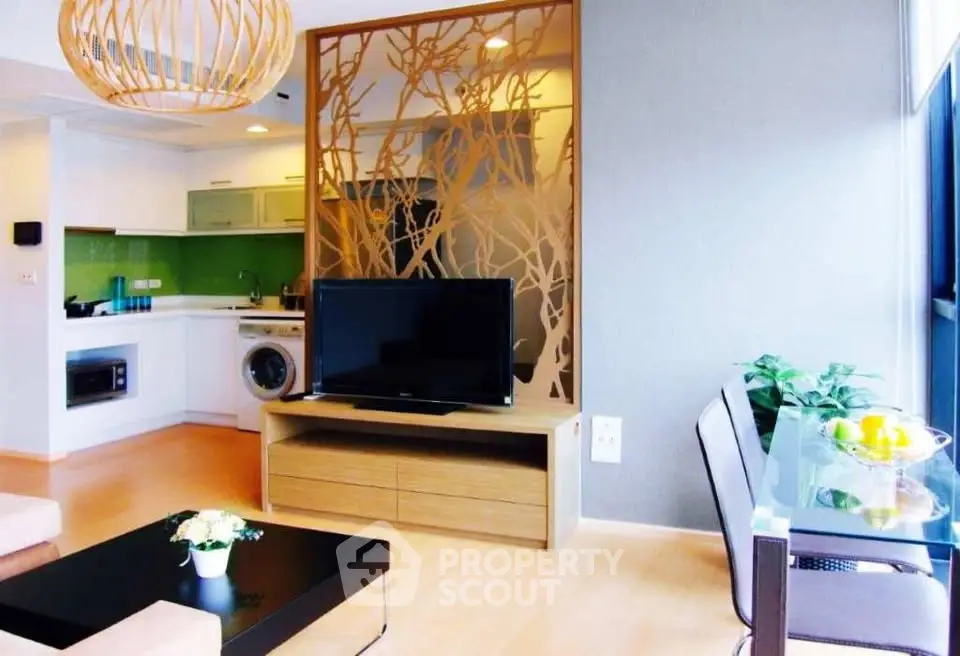 Modern living room with open kitchen, stylish decor, and natural light