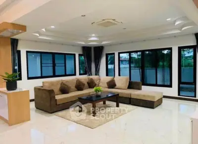 Spacious modern living room with large windows and stylish corner sofa
