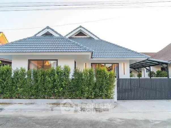 Charming single-story house with modern roof and lush greenery