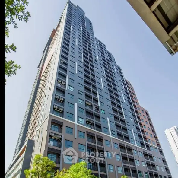 Stunning high-rise building with modern architecture and lush greenery at the base.