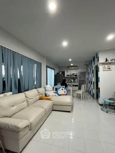 Spacious living room with modern decor and cozy seating area, perfect for relaxation and entertainment.