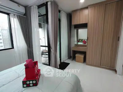 Modern bedroom with balcony access, featuring sleek wardrobe and stylish vanity in a high-rise apartment.