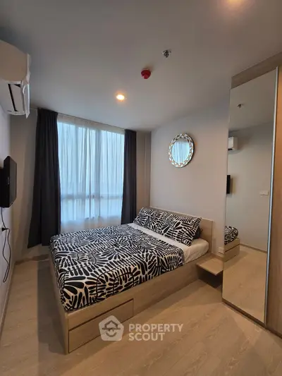 Modern bedroom with stylish decor and natural light in a cozy apartment.