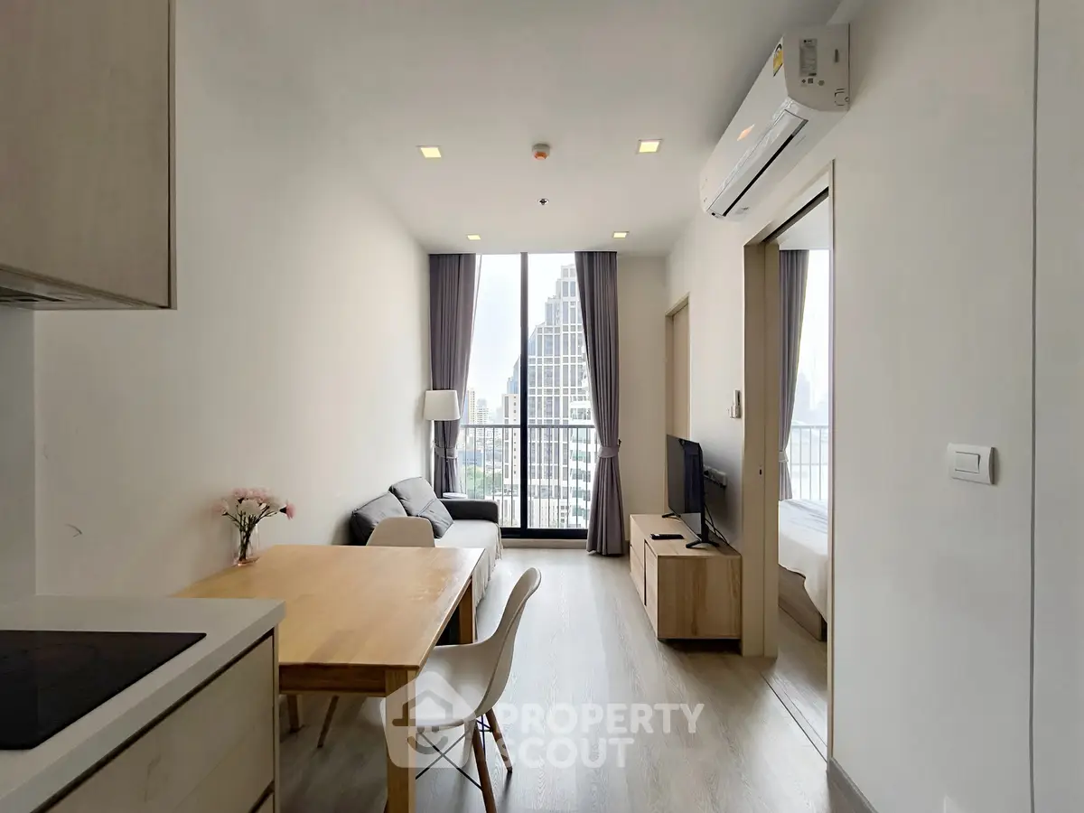 Modern living room with city view, featuring sleek furniture and natural light, perfect for urban living.