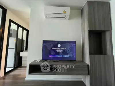 Modern living room with wall-mounted TV and air conditioning in stylish apartment.