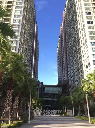 Stunning high-rise residential buildings with lush landscaping and clear blue sky.