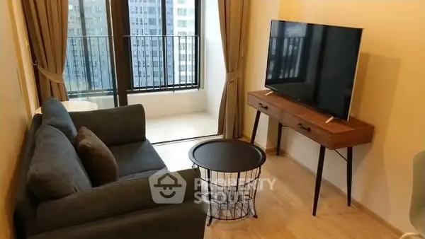 Modern living room with balcony view, featuring sleek furniture and large TV.