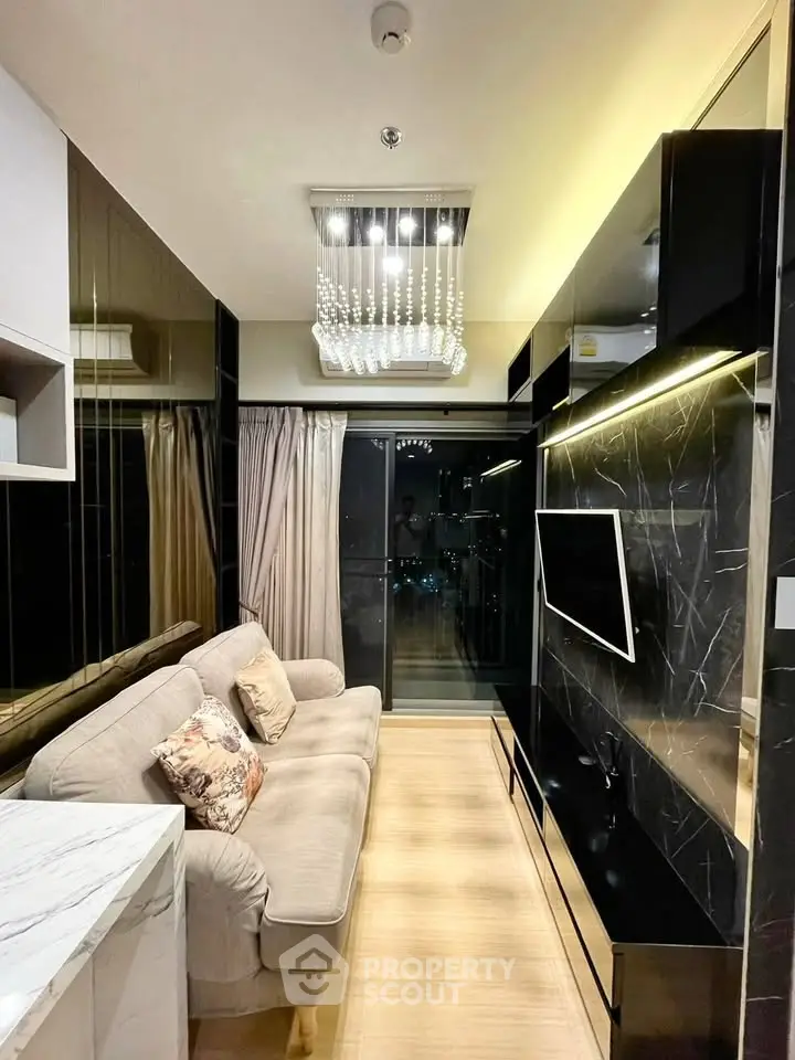 Luxurious modern living room with elegant chandelier and sleek black marble accents.