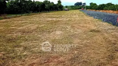 Expansive vacant land ideal for development with lush greenery and clear skies.