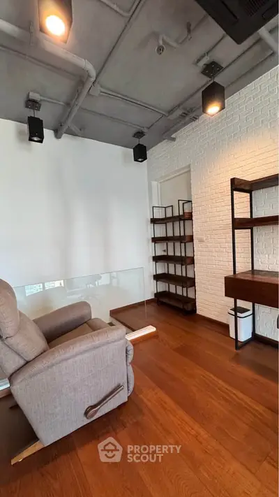 Modern living room with stylish shelving and comfortable recliner chair on wooden flooring.