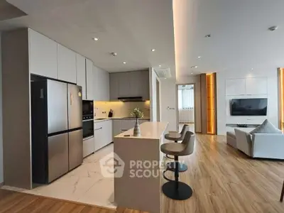 Modern open-layout kitchen and living room with sleek design and stylish furnishings.