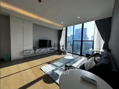 Modern living room with large windows and city view, featuring stylish furniture and natural light.