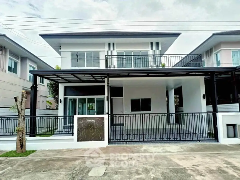 Modern two-story house with sleek balcony and spacious driveway in suburban neighborhood.